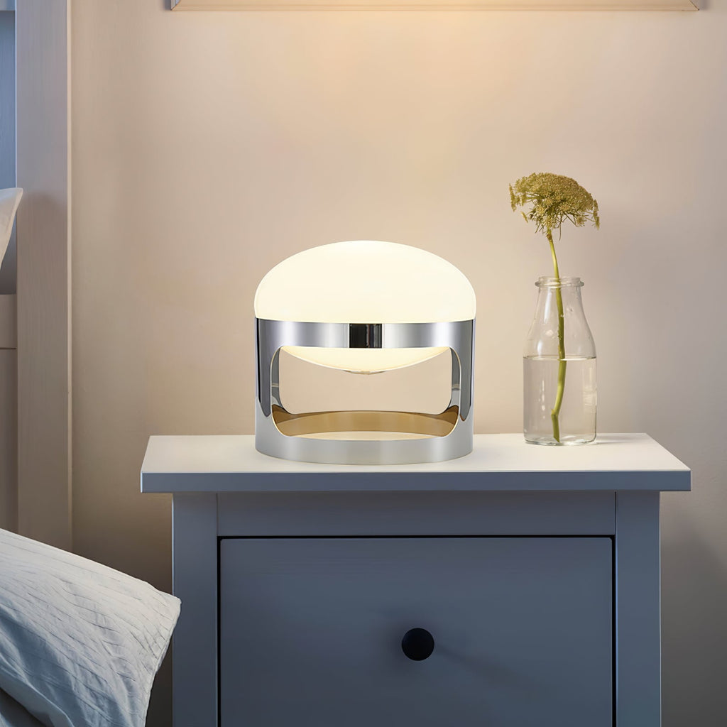 This Clérachic table lamp lights a navy bedside chest with a drawer, beside a glass bottle holding a single dried stem.