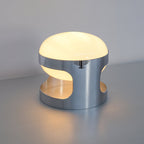 Clérachic table lamp seen from a three-quarter angle, showing the opal dome and the polished chrome band with its side cutouts.