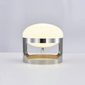 This Clérachic table lamp lit on a pale grey backdrop, its dome glowing soft white above the chrome band.