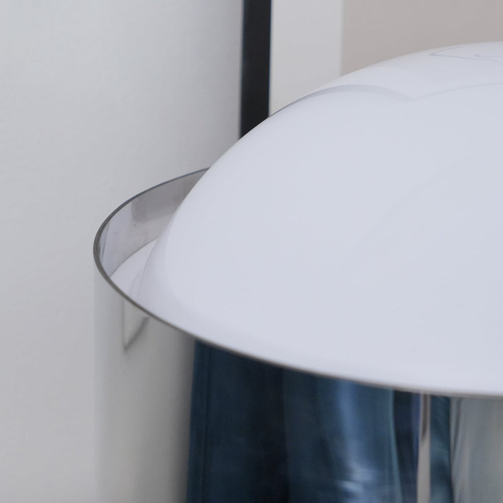 Close view of the curved edge of the opal white dome on this Clérachic table lamp, with the chrome band below it.