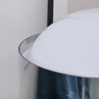 Close view of the curved edge of the opal white dome on this Clérachic table lamp, with the chrome band below it.