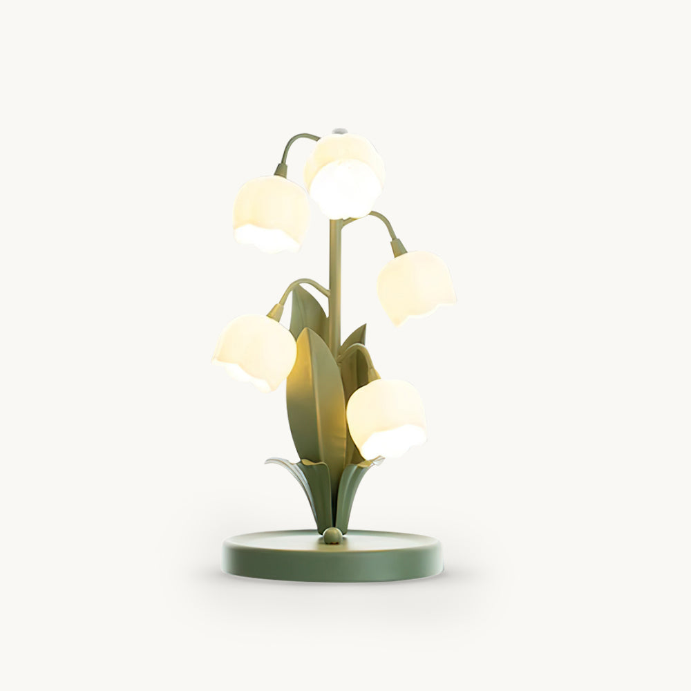 A Clérachic table lamp with five lit frosted white bell-flower shades on curved green stems, on a round green base, against a white backdrop.