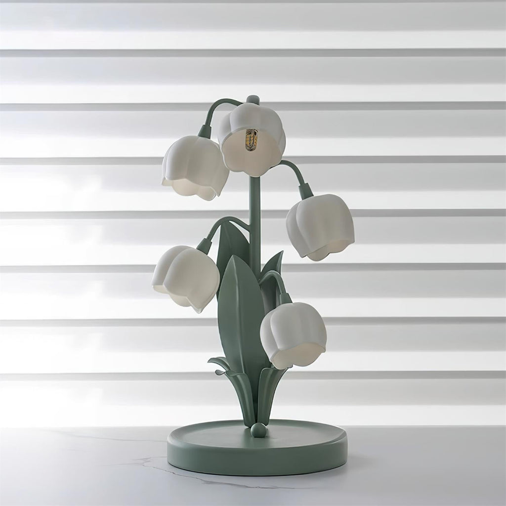 The Clérachic table lamp switched off, its white bell shades and green stems against striped window blinds.
