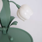 Close view of a bell shade and the leaf blades on the green base of this unlit Clérachic table lamp.