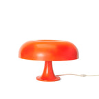 Orange Clérachic mushroom table lamp on a plain white backdrop, with its cord and in-line switch visible on the right.