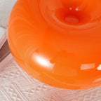 Close view of the glossy orange dome and the small opening at its centre on this Clérachic table lamp.