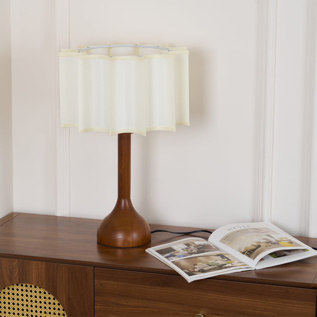 Clérachic table lamp unlit on a wooden cabinet, with an open magazine at the foot of its rounded base.