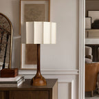 Clérachic table lamp on a dark cabinet in a panelled hallway, with a mirror and framed sketch behind.