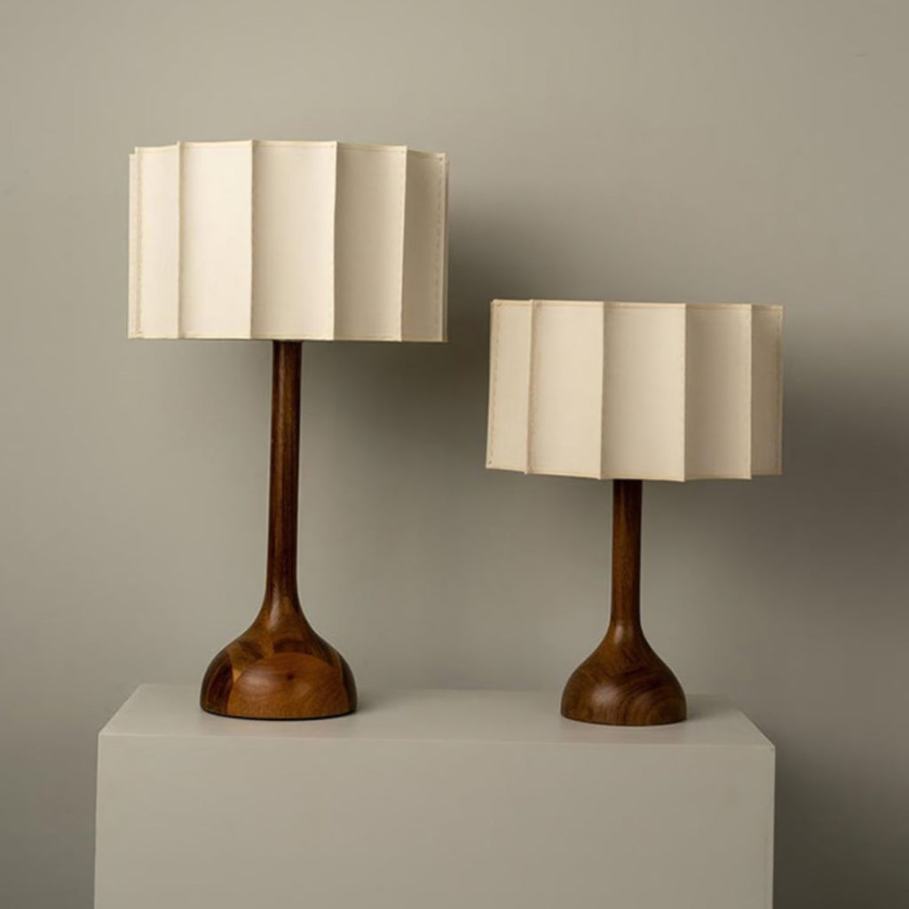 Two Clérachic table lamps of different heights on a white plinth against a sage-grey wall.
