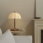 Lit Clérachic table lamp on a low table with a teacup and saucer, beside a white sofa and a white mantel.