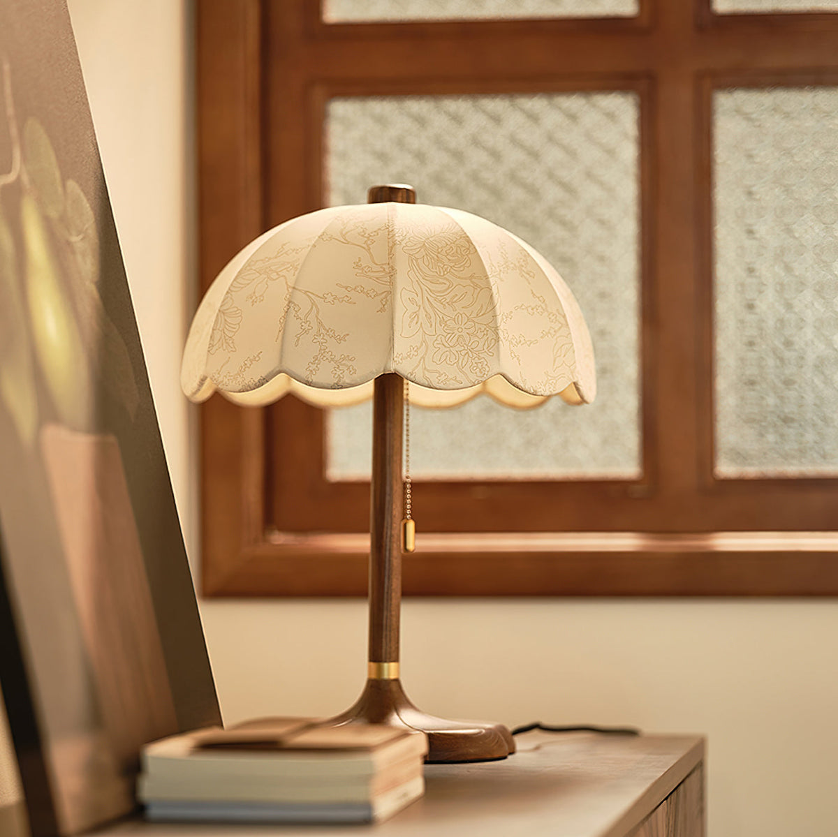 Three-quarter view of this Clérachic table lamp on a sideboard, with its pull chain hanging beside the walnut stem.