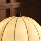 Close view of the ribbed, softly lit fabric shade and dark finial on this Clérachic table lamp.