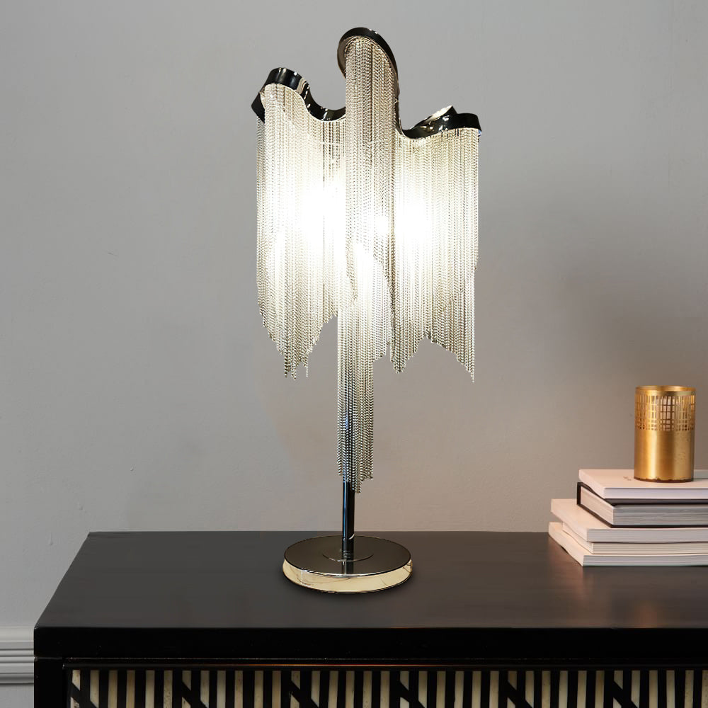 This Clérachic lamp on a black sideboard against a grey wall, with a stack of books and a small gold candle beside it.