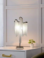A Clérachic table lamp on a white cabinet in a panelled room, with a small potted plant beside it.