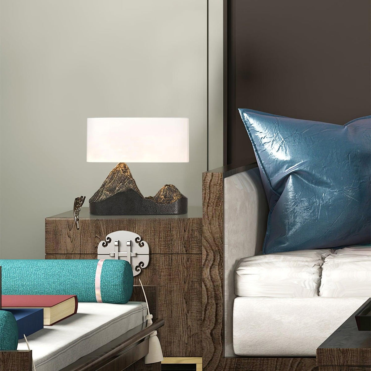 Small in a layered living scene, this Clérachic mountain-base lamp sits on a wood chest beside a sofa with a teal cushion.