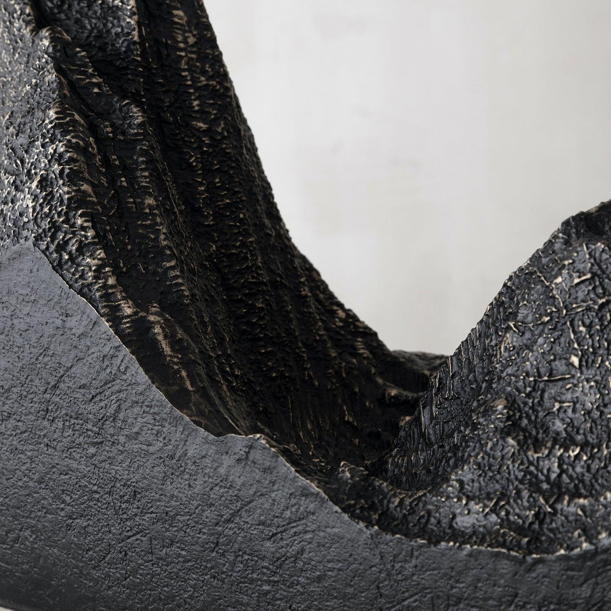 Close view of the rough, bronze-streaked mountain ridges rising from the black base of this Clérachic table lamp.