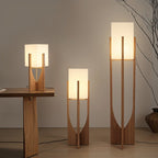 Clérachic wooden-framed lamps with white rectangular shades in three heights, lit against a grey wall.