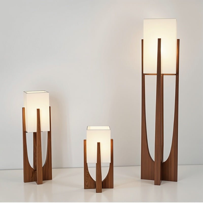 Clérachic walnut-framed lamps with white fabric shades in three heights, lit on a pale surface.