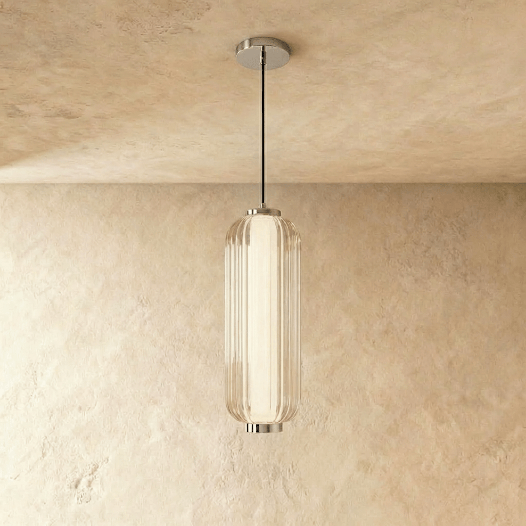 Clérachic ribbed clear glass pendant with chrome fittings and a thin black cable, hanging in a studio shot on warm limewash.
