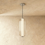 Clérachic ribbed clear glass pendant with chrome fittings and a thin black cable, hanging in a studio shot on warm limewash.