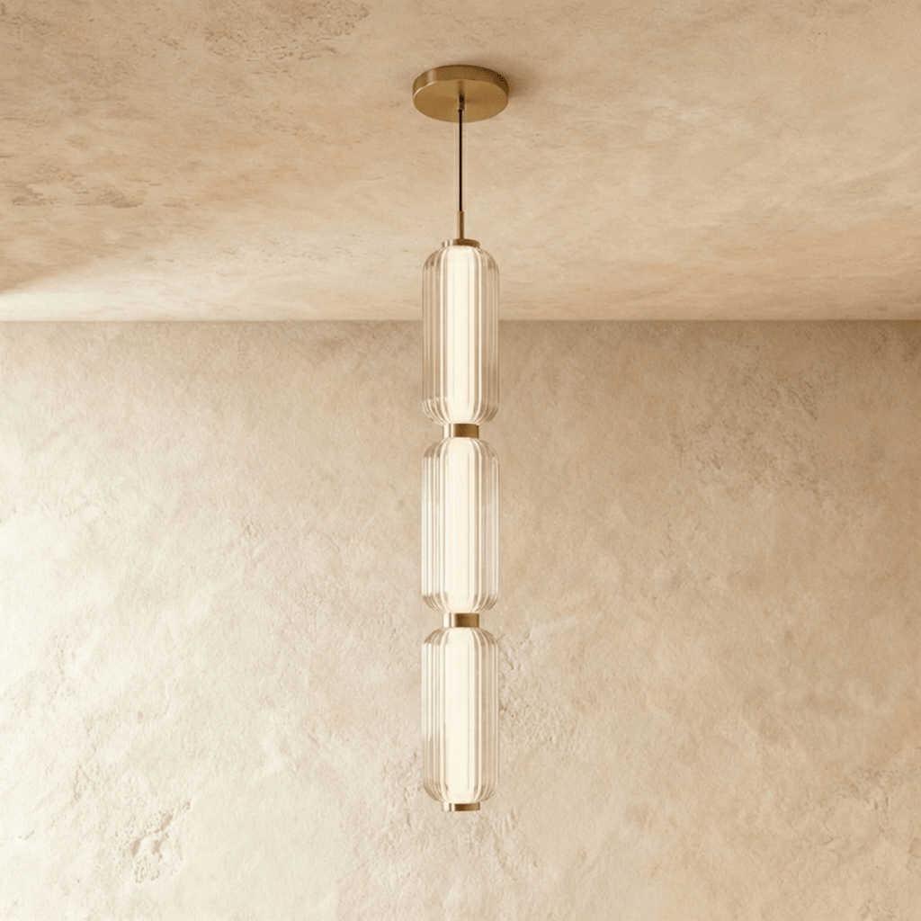 Clérachic three-tier ribbed glass pendant with soft gold fittings, a tall slim column of light hung in the studio.