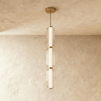 Clérachic three-tier ribbed glass pendant with soft gold fittings, a tall slim column of light hung in the studio.