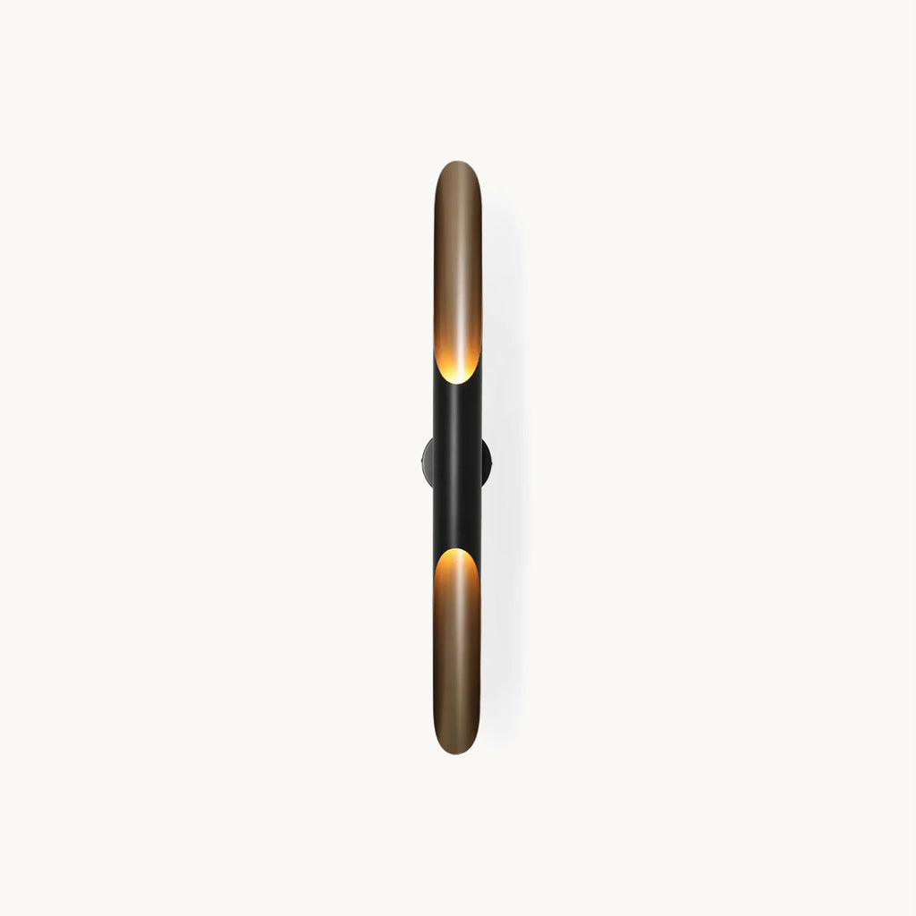 A tall slim wall light on a plain white backdrop: two matt black and gold tubes with open, angled mouths, from Clérachic.