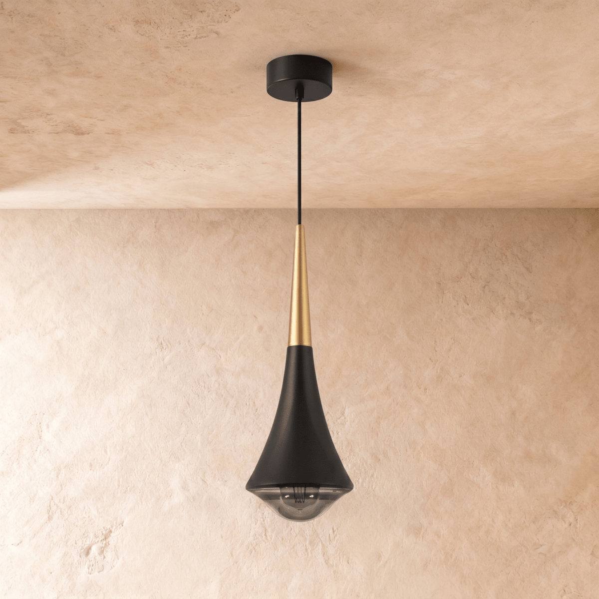 Clérachic black tapered pendant with a gold-toned neck and a smoked glass base, hanging against a limewash wall.