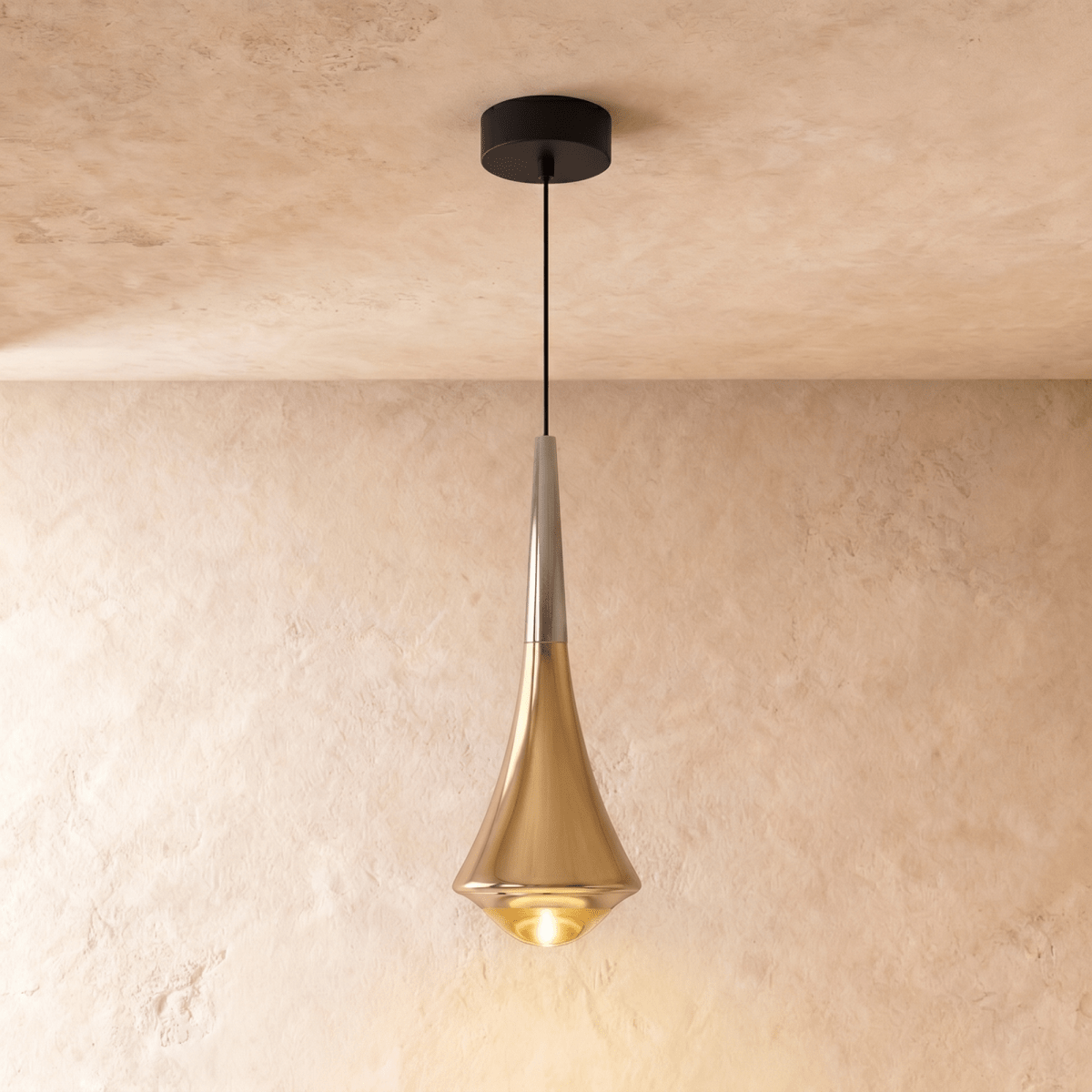 Clérachic tapered pendant in polished gold with a silver-toned neck and a glowing glass base, on a limewash wall.