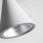 Close view of the lit inner rim and silver reflector of a light grey concrete Clérachic pendant shade.