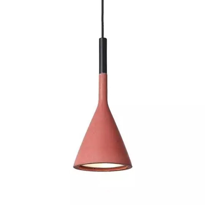 Front view of a Clérachic pendant in a coral-red concrete shade on white, with a black collar and a glowing opening.