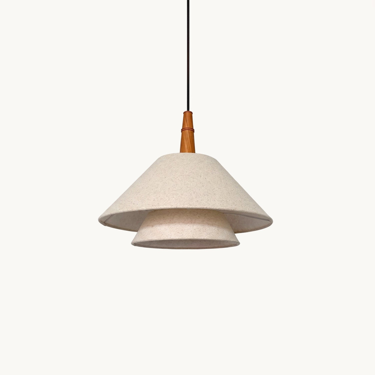 A two-tier linen pendant from Clérachic with a turned wooden neck and a black cord, on a plain off-white backdrop.