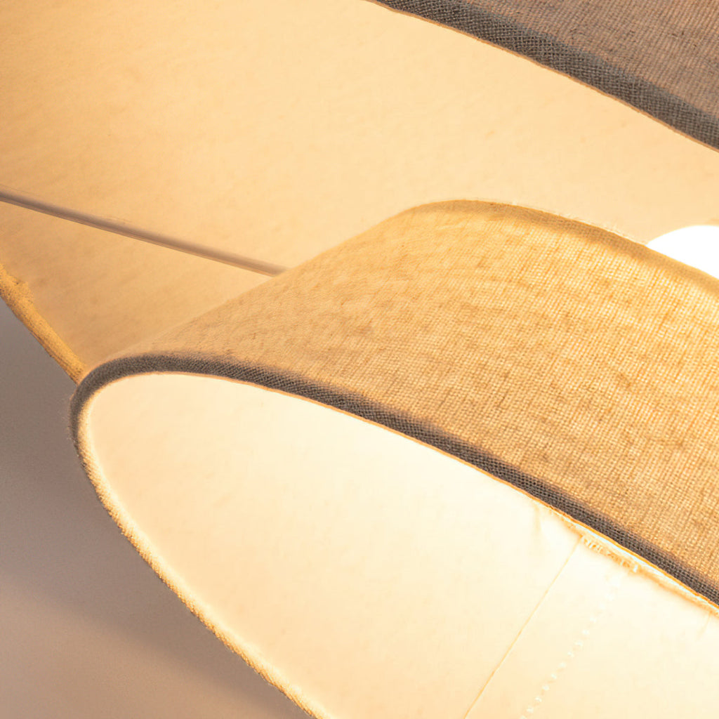 Close view of the glowing linen rim and the lit inner shade of this Clérachic pendant.