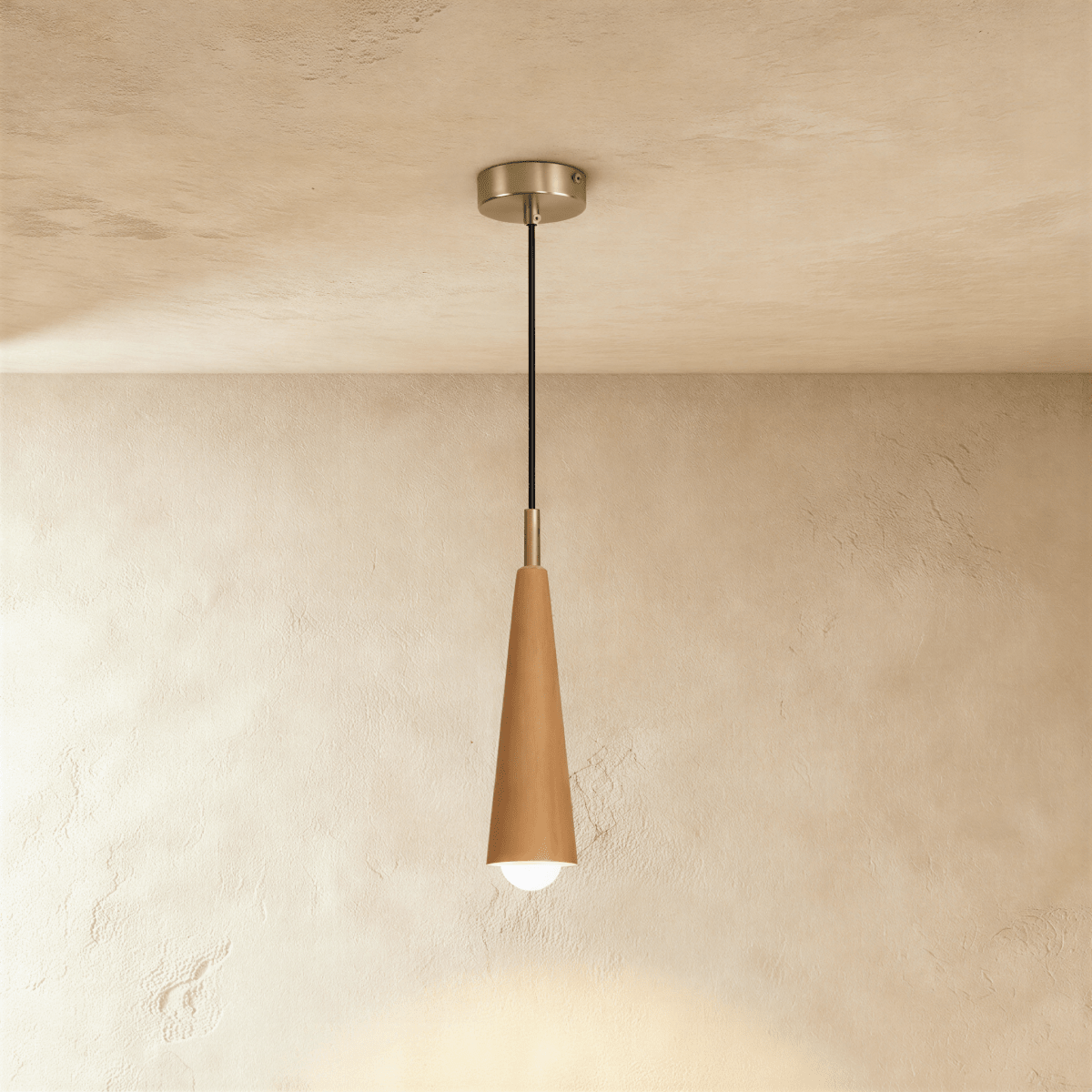 Clérachic tapered wooden cone pendant in a light natural finish with a silver-tone canopy and a bare globe bulb, on limewash plaster.