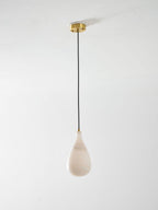 Small unlit Clérachic alabaster drop hanging from a brass ceiling plate on a thin black cord, on a pale backdrop.
