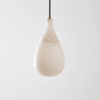 Unlit Clérachic alabaster drop with soft cloudy veining, hanging on a dark cord against a light grey backdrop.