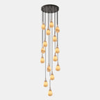 A tall cascade of lit alabaster drops hangs at staggered heights from a round black canopy on this Clérachic pendant.