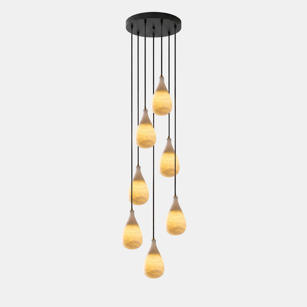 Seven lit alabaster drops hang at different lengths from a round black canopy on this Clérachic pendant.