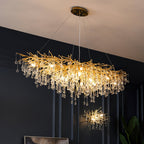 The long Clérachic teardrop chandelier lit on a navy wall, a smaller matching piece beyond.
