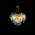 Clérachic teardrop chandelier photographed on black, glass drops massed under gold branches.
