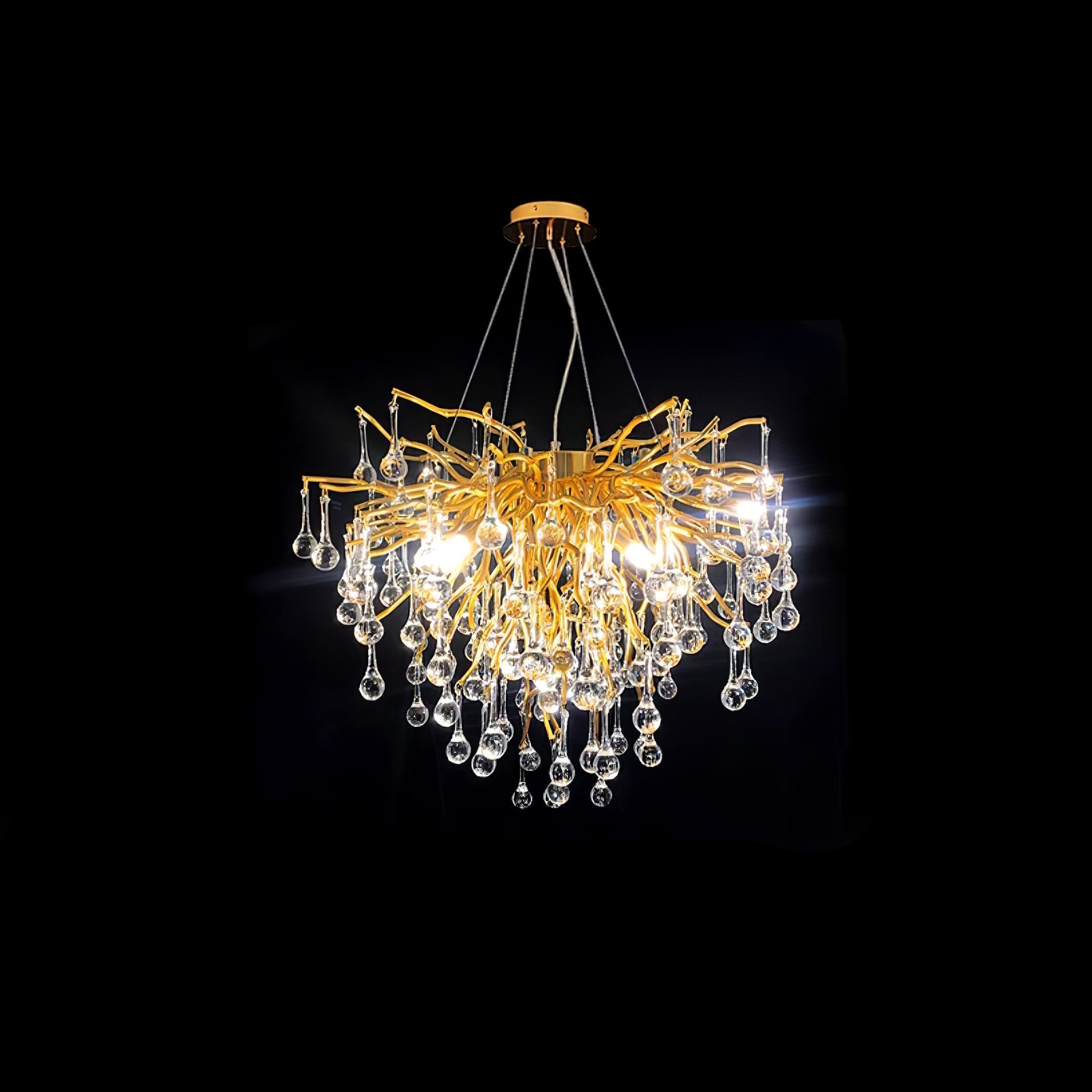 Clérachic teardrop chandelier photographed on black, glass drops massed under gold branches.