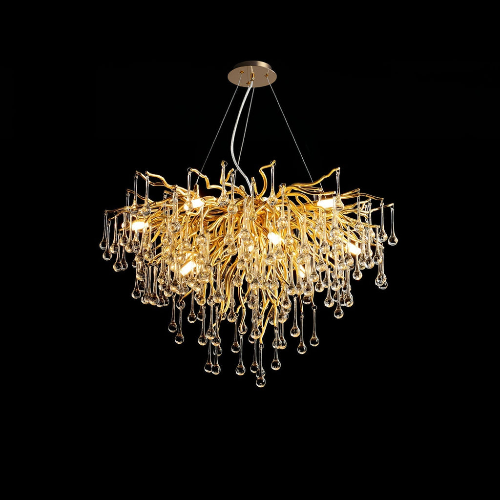 Clérachic teardrop chandelier on black, its gold branches spreading before the glass drops.