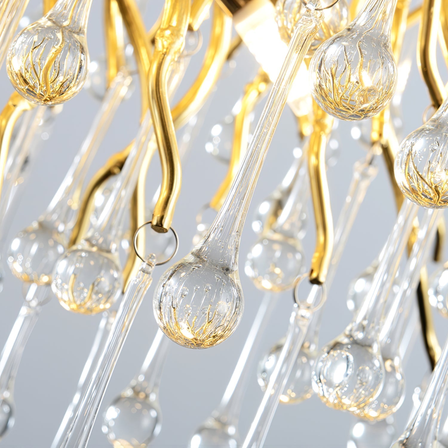 Macro of the Clérachic teardrop chandelier, showing the ribbed glass drops on gold hooks.