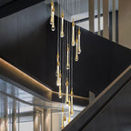 The 20-light Clérachic Teardrop Crystal Chandelier cascades in a stairwell with dark gray walls.