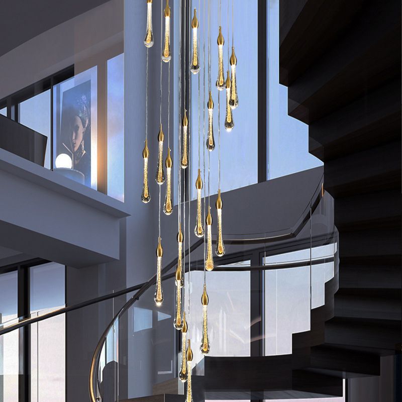 A 20-light Clérachic Teardrop Crystal Chandelier hangs in a spiral stair with a curved glass rail.