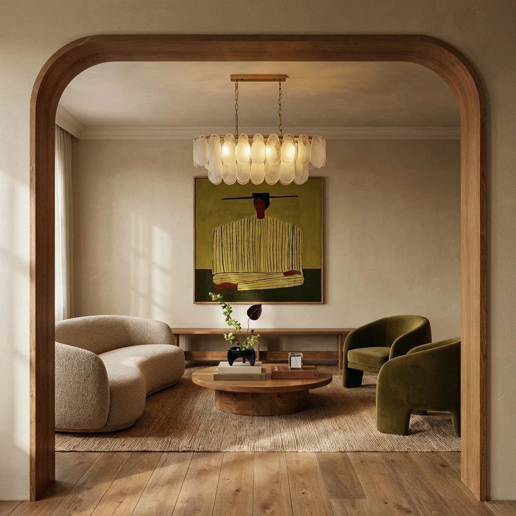 Clérachic linear glass chandelier lit warm above a low table, framed by an oak arch in a calm living room.