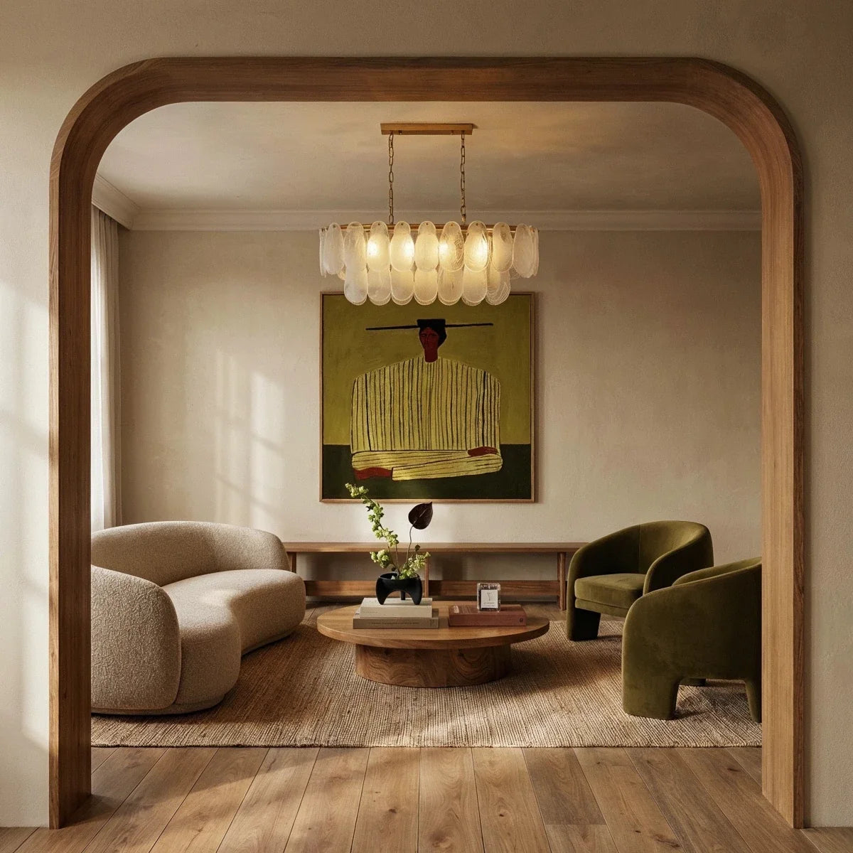 Clérachic linear glass chandelier lit warm above a low table, framed by an oak arch in a calm living room.