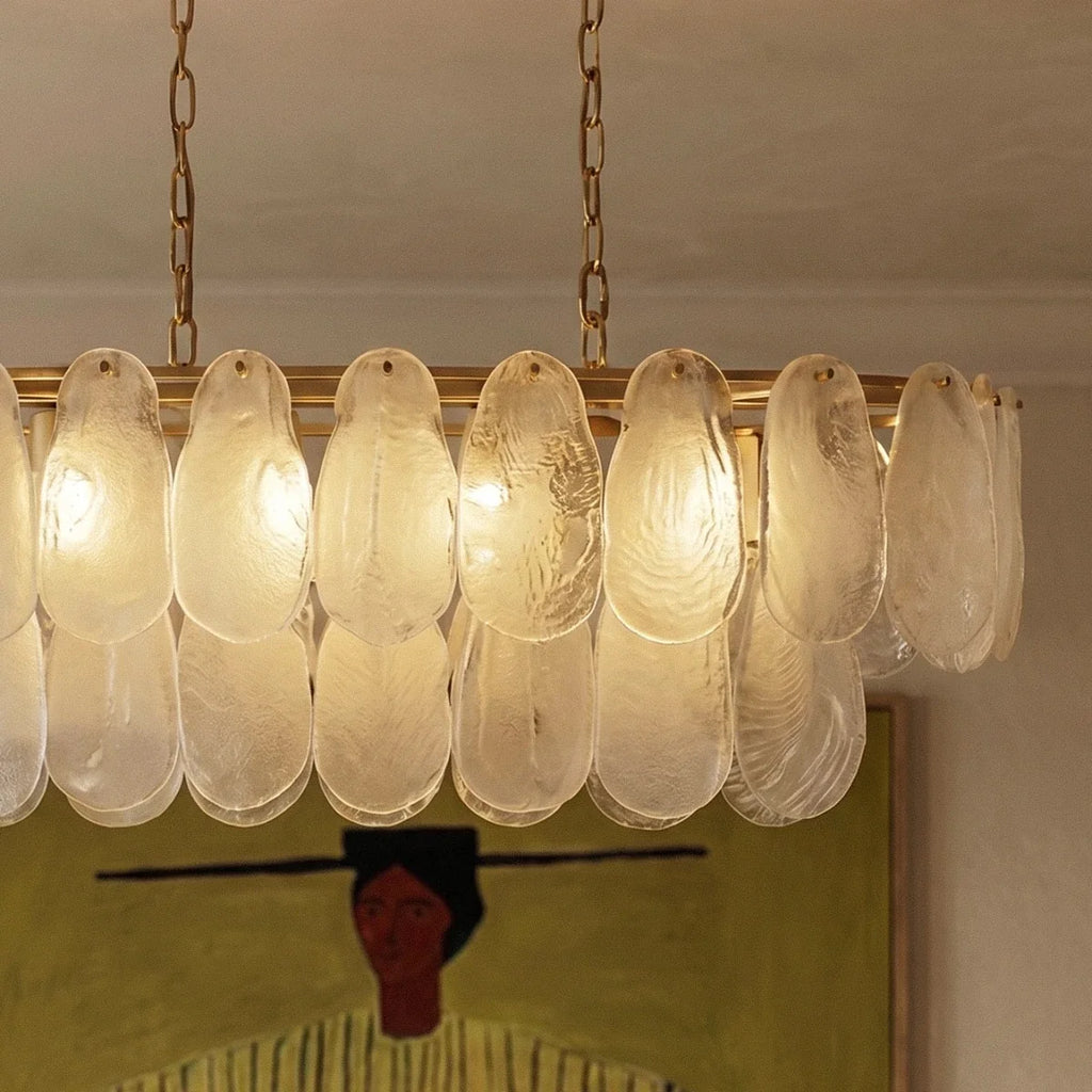 Close view of Clérachic frosted glass teardrop shades with swirled texture, pinned to a brass ring frame.