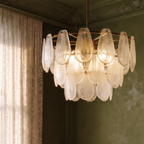 Clérachic round chandelier close up: layered frosted glass teardrops on a brass frame and central rod.