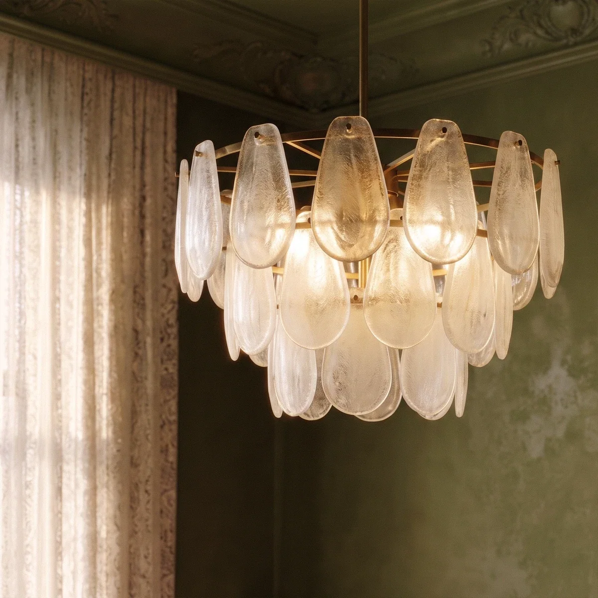 Clérachic round chandelier close up: layered frosted glass teardrops on a brass frame and central rod.